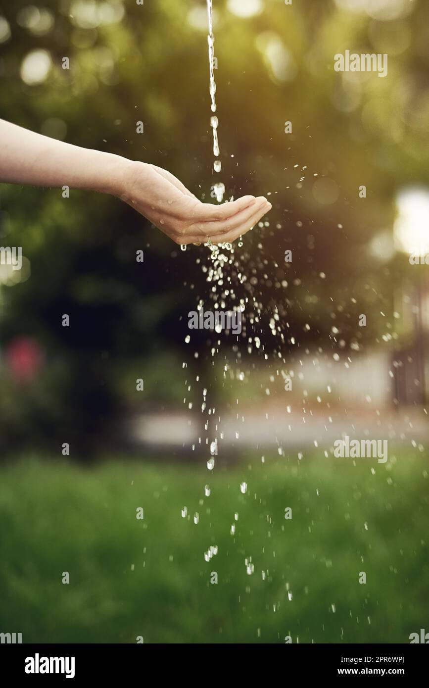Water is life, dont waste it. Cropped shot of water running on a womans hand outside. Stock Photo