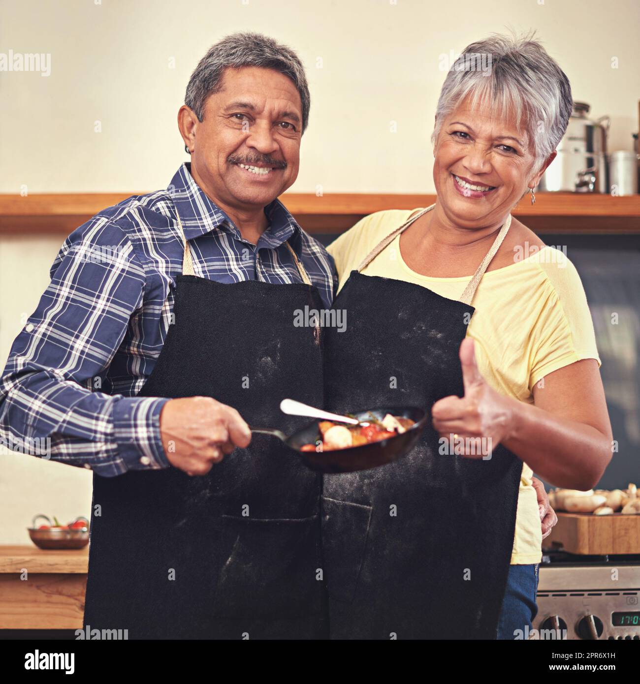 Dinner is served. Shot of a mature couple cooking together at home. Stock Photo