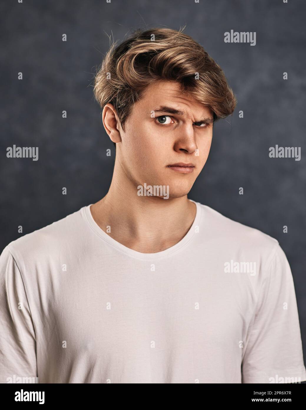 young handsome man with a doubt on his face in t-shirt Stock Photo