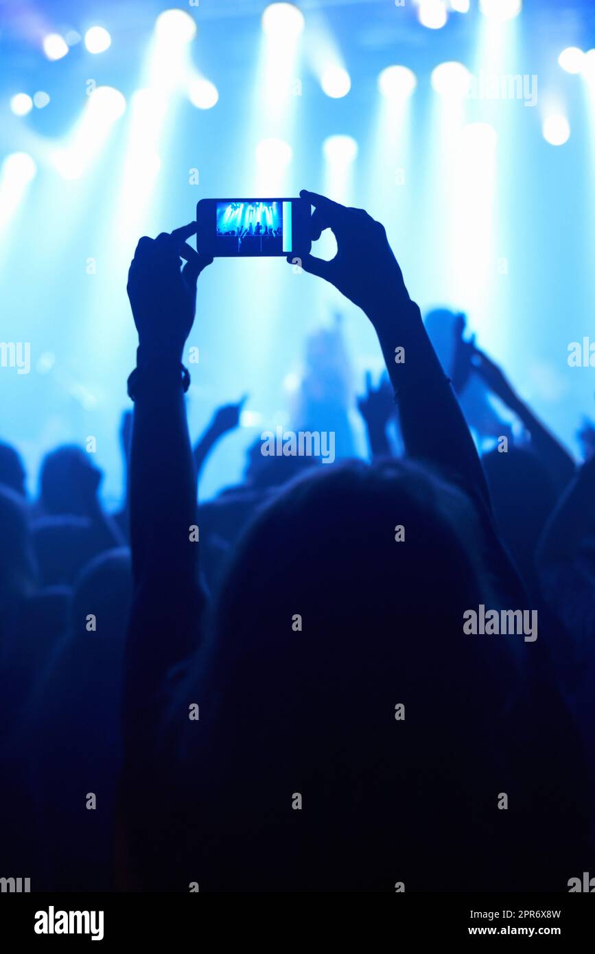 Capturing the moment. A person filming their favourite band with a camera phone. Stock Photo