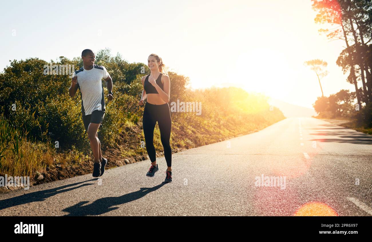 Taking their run out on the open road. Shot of a fit young couple going for a run outdoors. Stock Photo