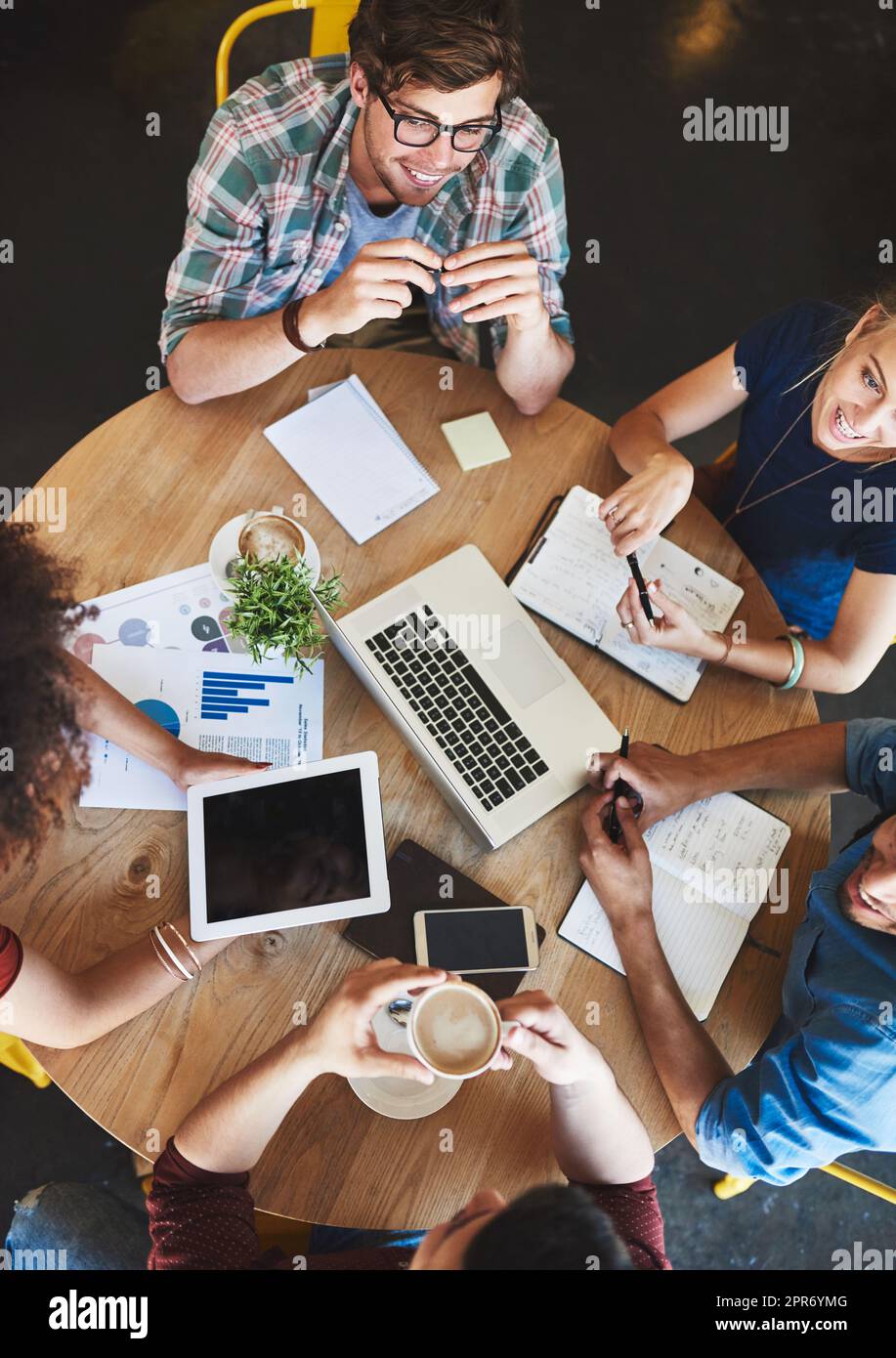 We have all the information we need to pass exams. High angle shot of a group of students studying in a coffee shop. Stock Photo