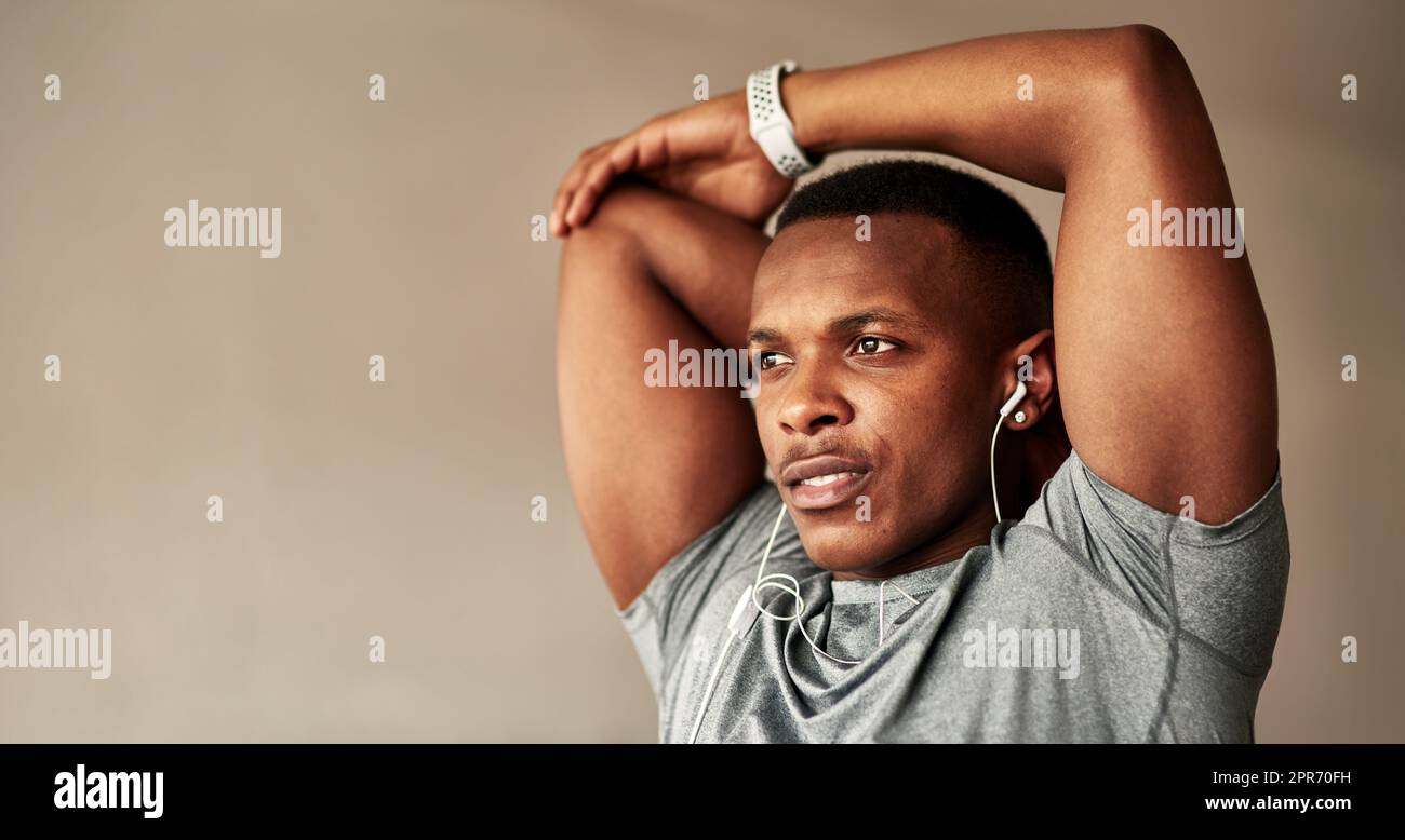 Lets start this day the right way. Cropped shot of a sporty young man stretching at home. Stock Photo