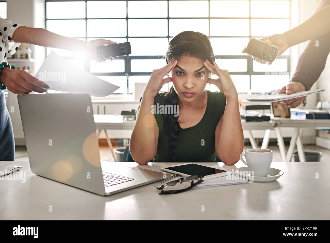 Work overload. Shot of a stressed out businesswoman surrounded by colleagues needing help. Stock Photo
