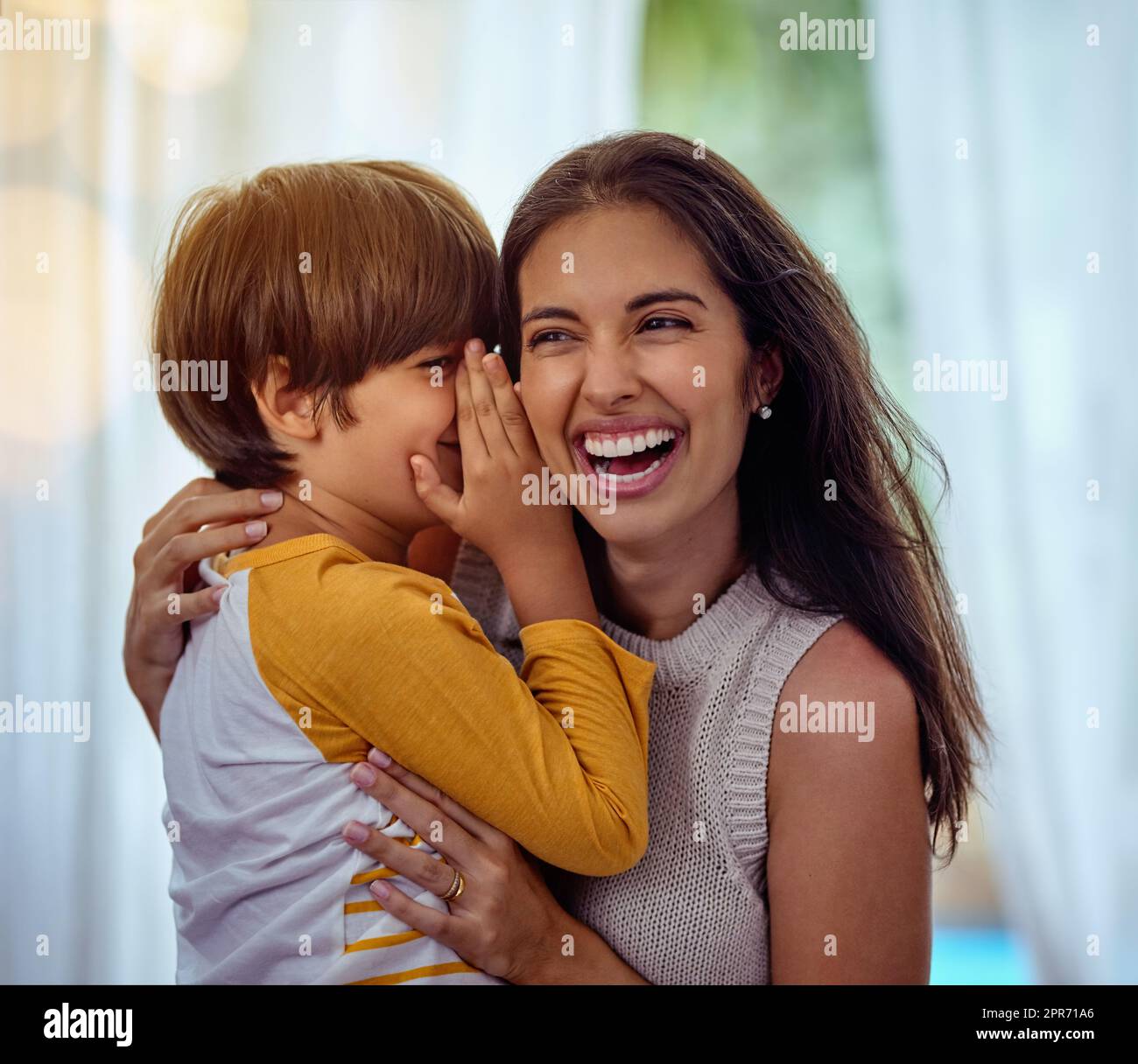 Hey mom guess what I love you. Shot of an adorable little boy whispering into his mothers ear. Stock Photo