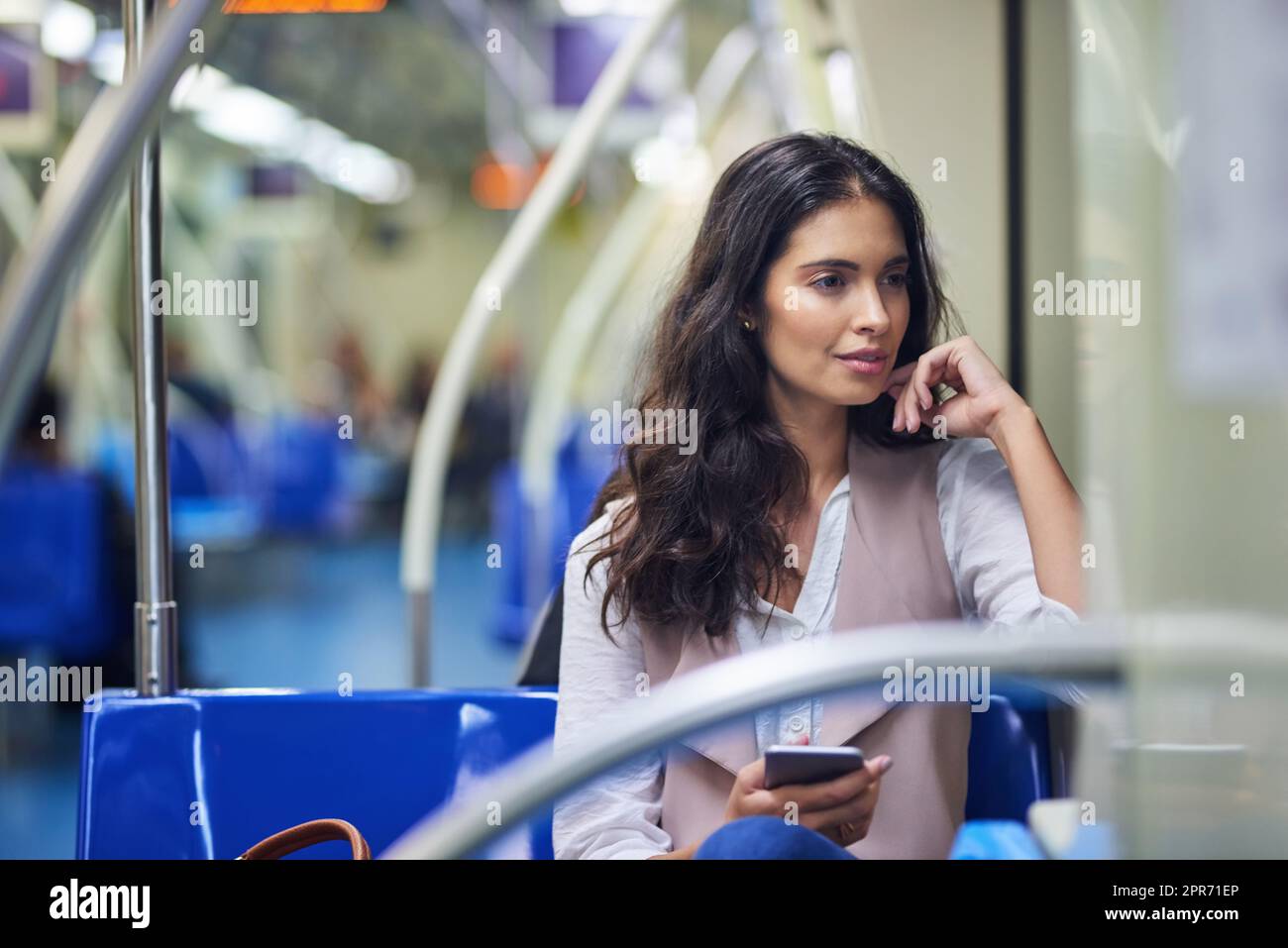 The train can sometimes be a great place to think. Cropped shot of a young attractive woman using a cellphone while commuting with the train. Stock Photo
