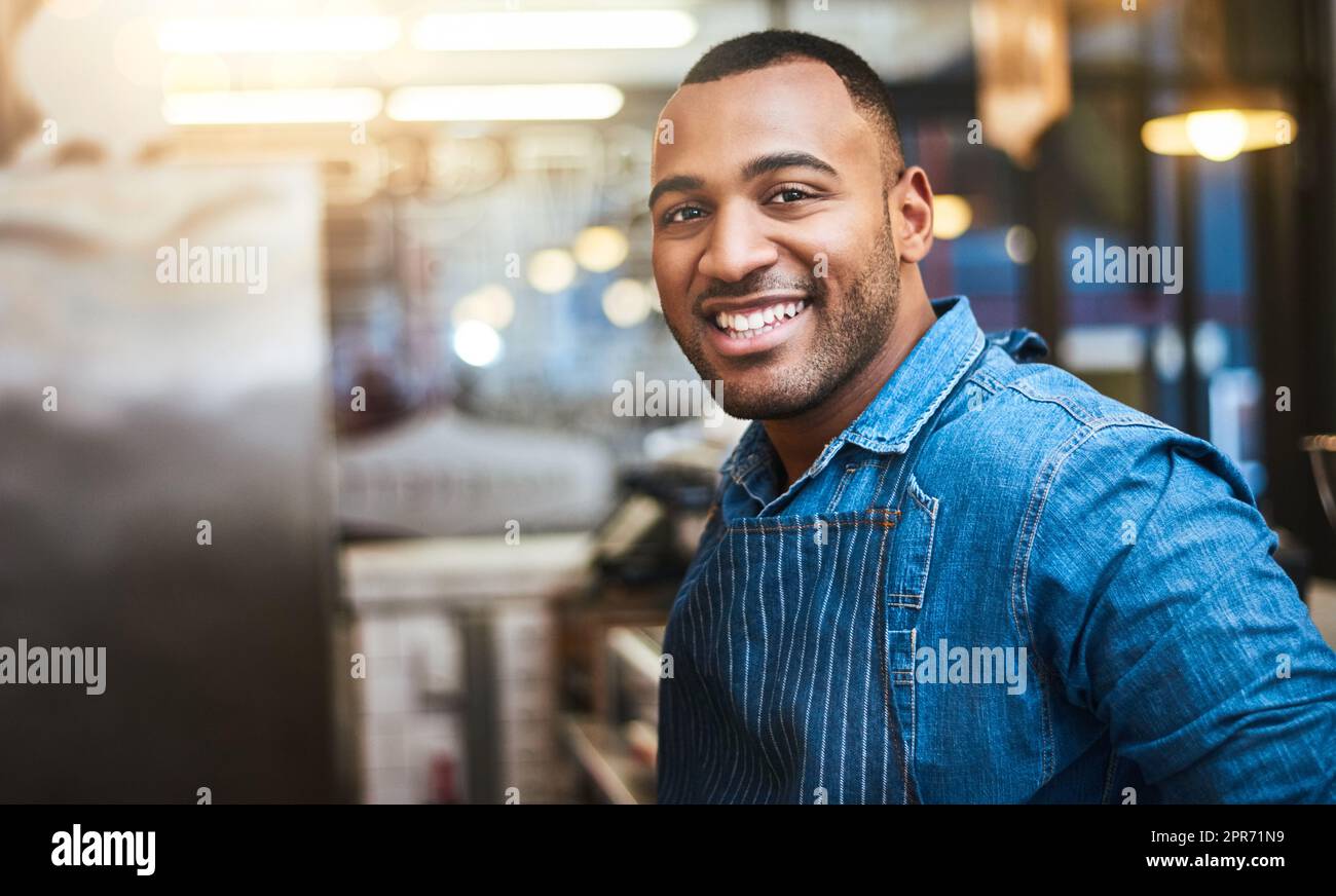 My service is even better than my smile. Cropped portrait of a handsome young man standing in his coffee shop. Stock Photo