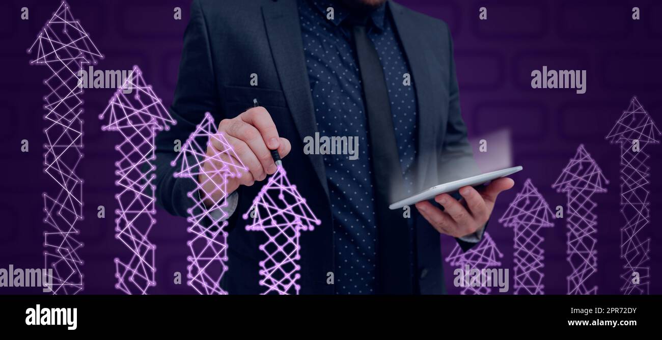 Businessman Wearing Suit Holding Tablet And Pen Drawing Arrows Going Up With Digitally Generated