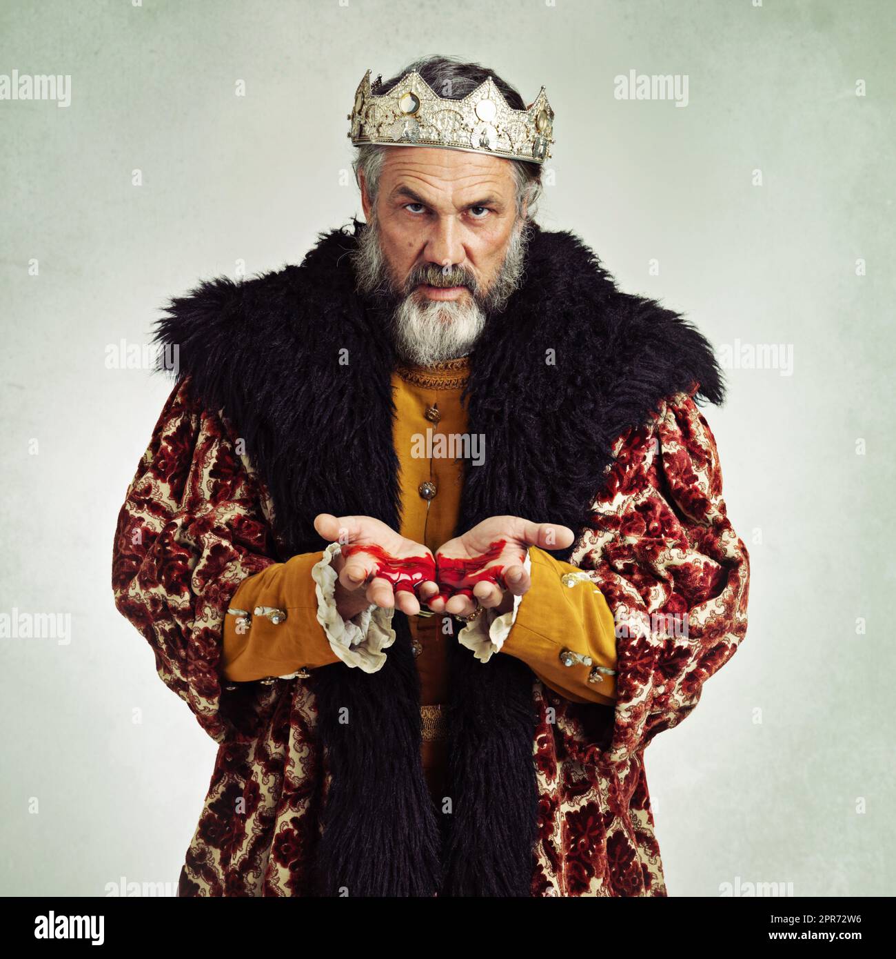 The king is dead Long live...ME. Shot of a mature king with blood on his hands. Stock Photo