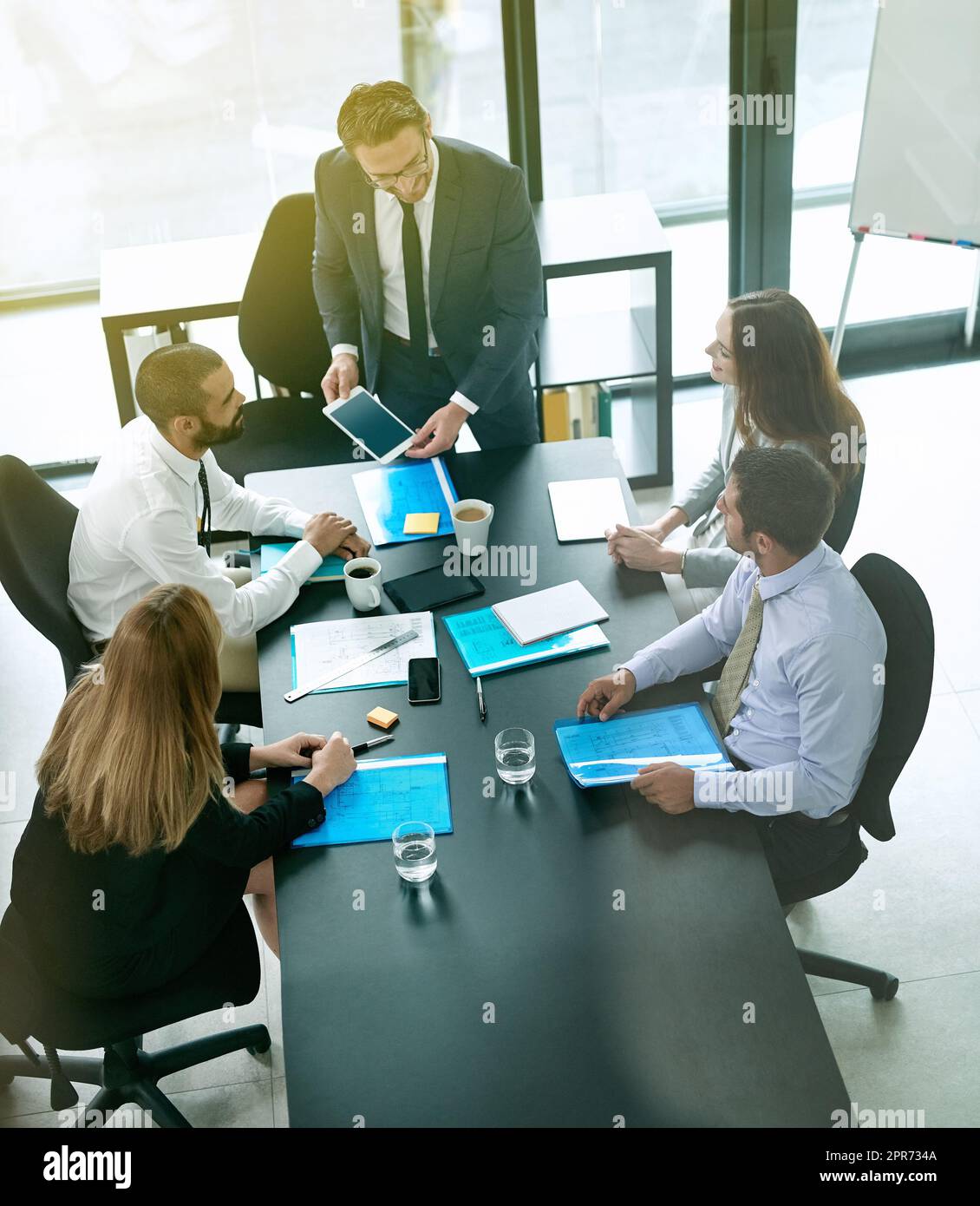 Im happy to roll out this new information to everybody. Shot of a team of executives having a formal meeting in a boardroom. Stock Photo