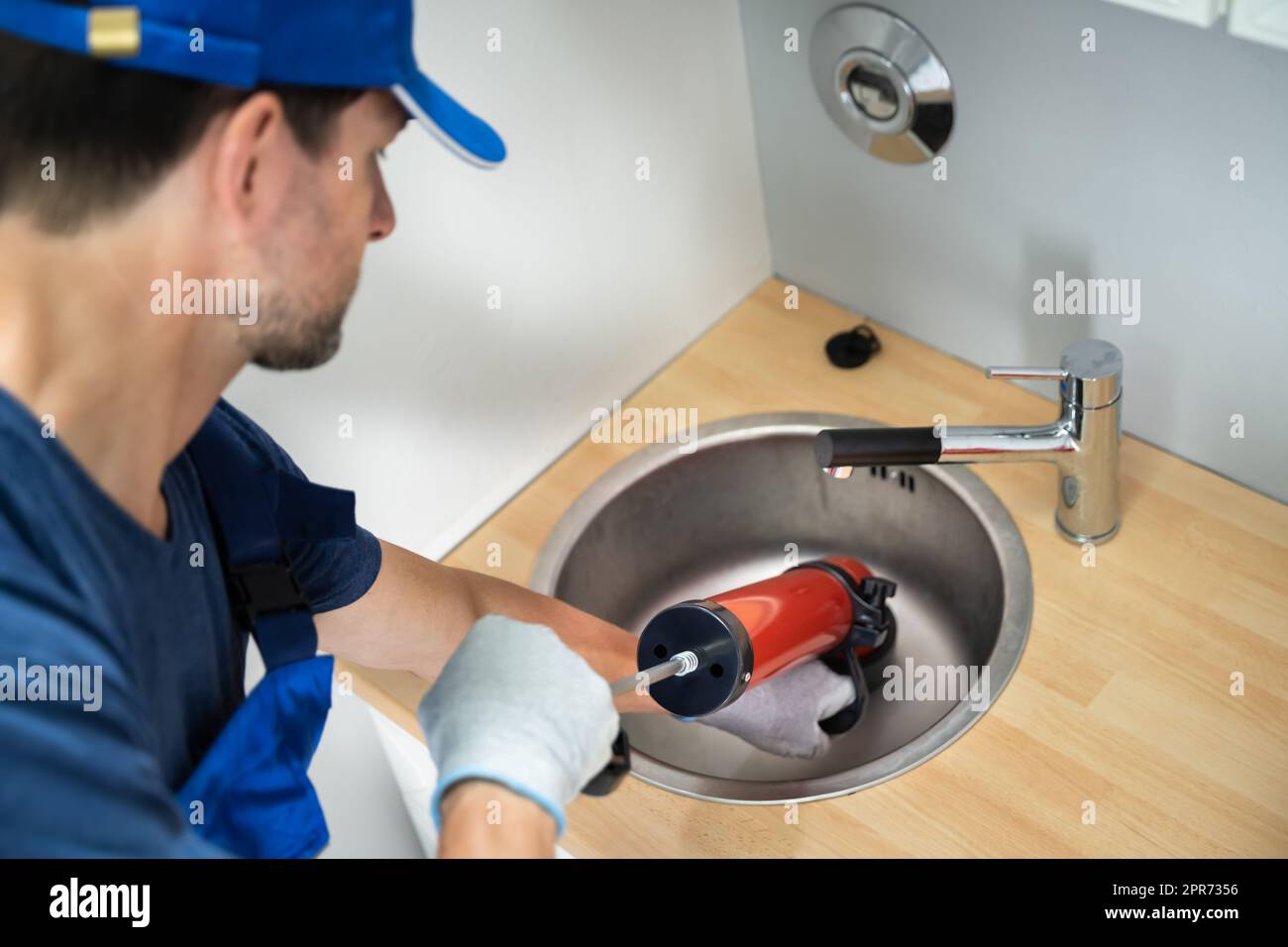 Plumber Cleaning Drain And Sink Stock Photo
