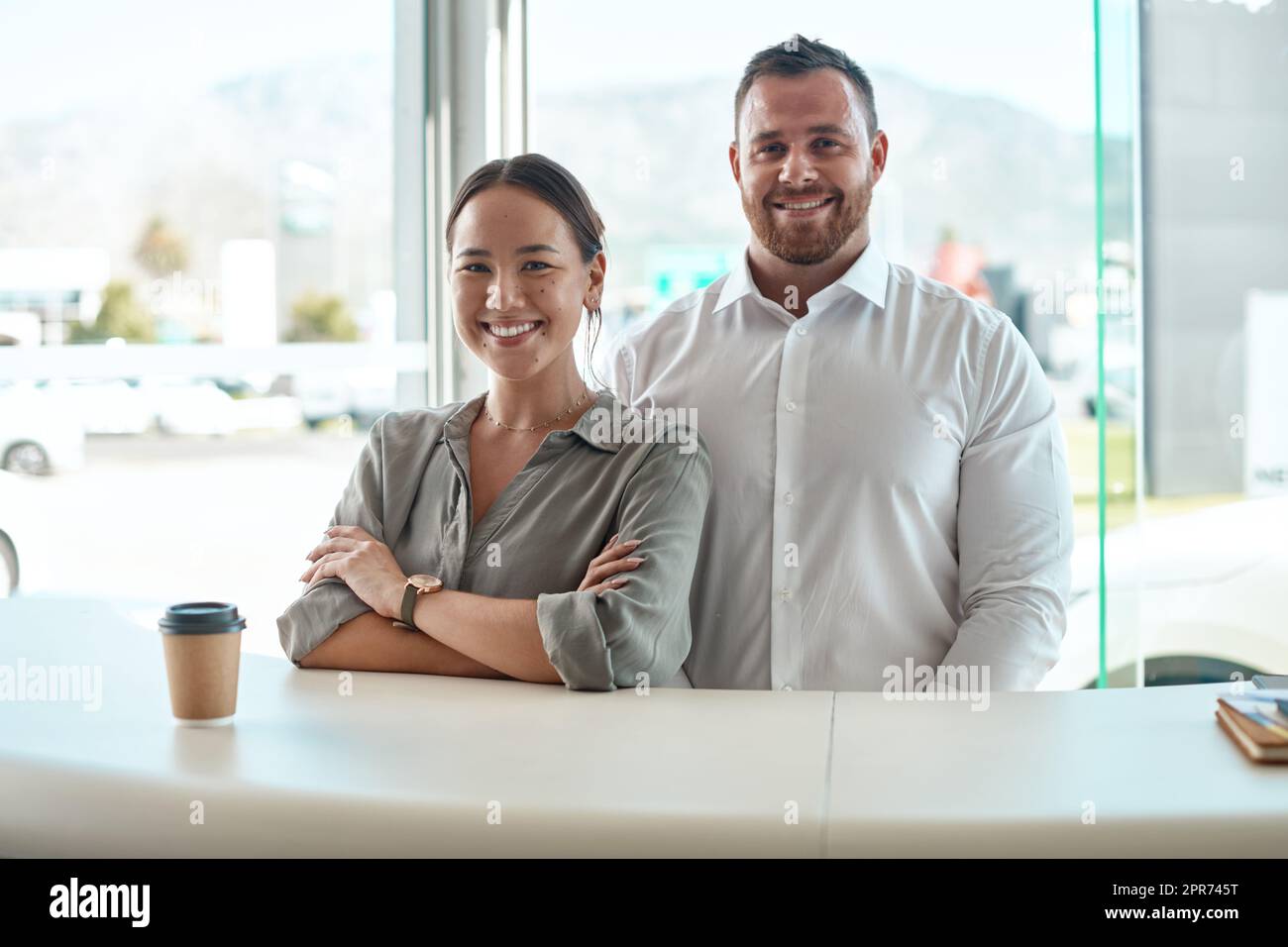 This is the dream team. Shot of a customer with her car salesman in the dealership. Stock Photo