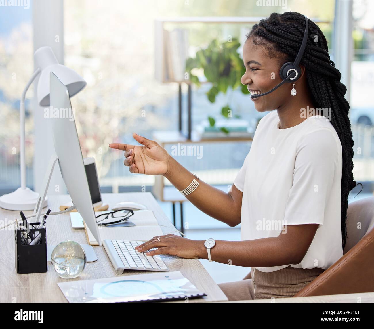 Shes got the best advice. Shot of a young female call center agent using a computer at work. Stock Photo