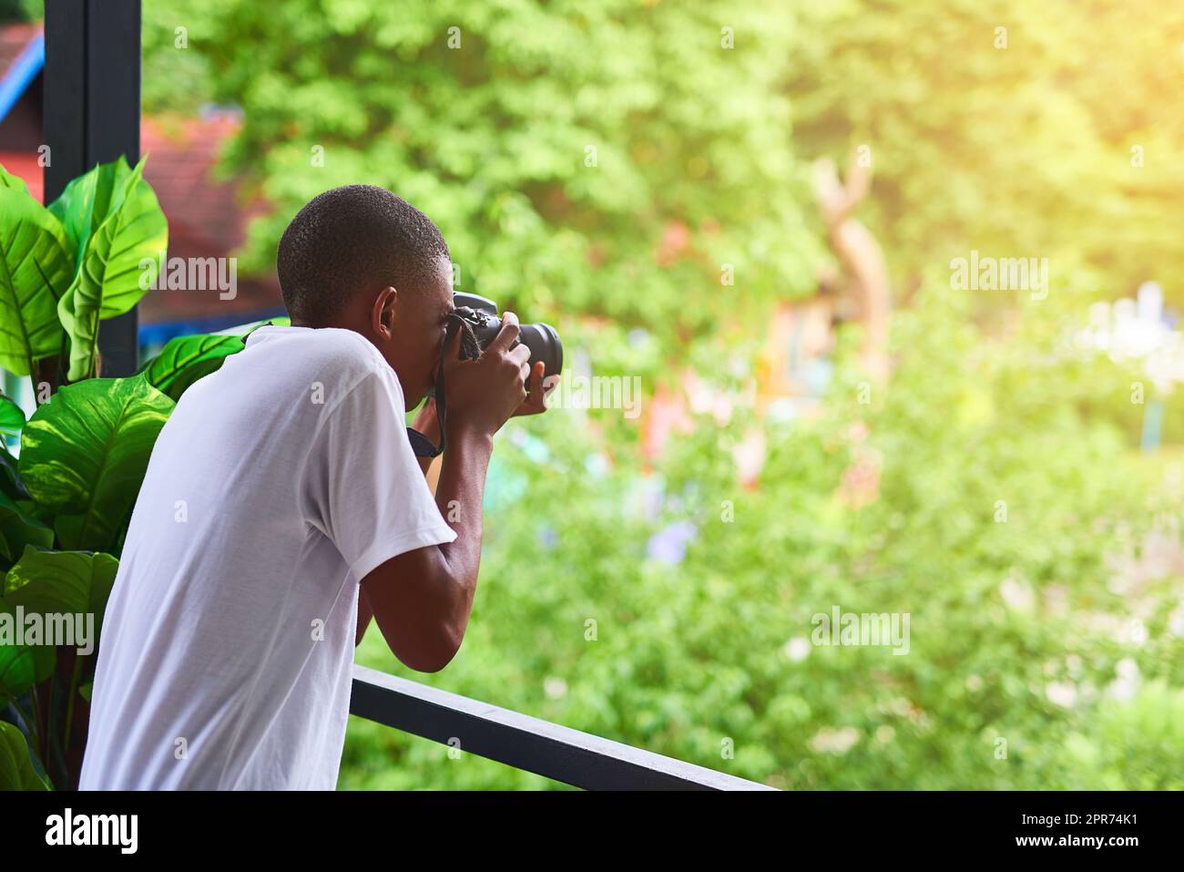 He loves shooting people from his balcony. Shot of an unidentifiable tourist taking a picture from his balcony. Stock Photo