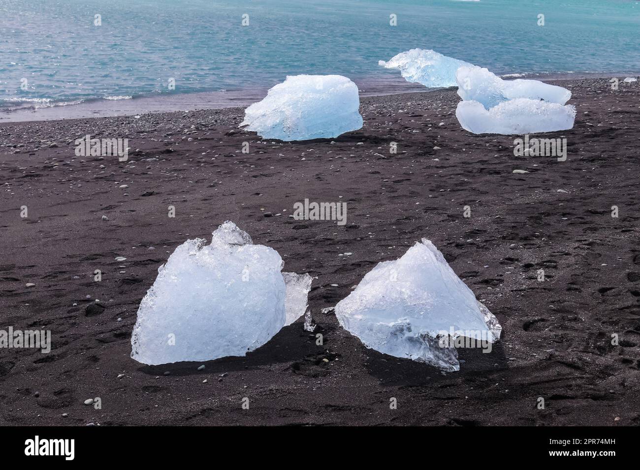Diamond Beach in Iceland with blue icebergs melting on black sand and