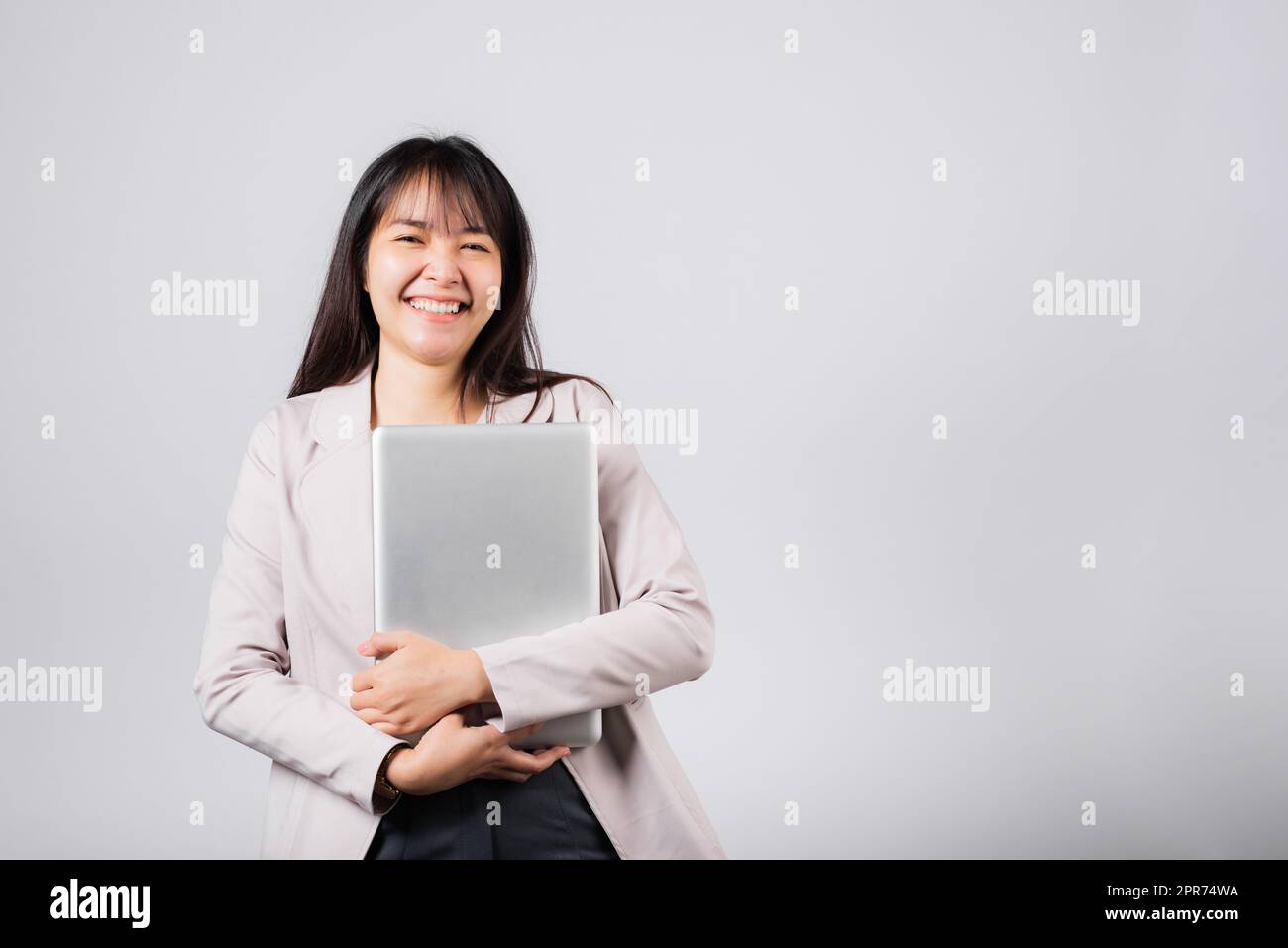 Front view woman smiling confident smiling holding closed laptop Stock Photo