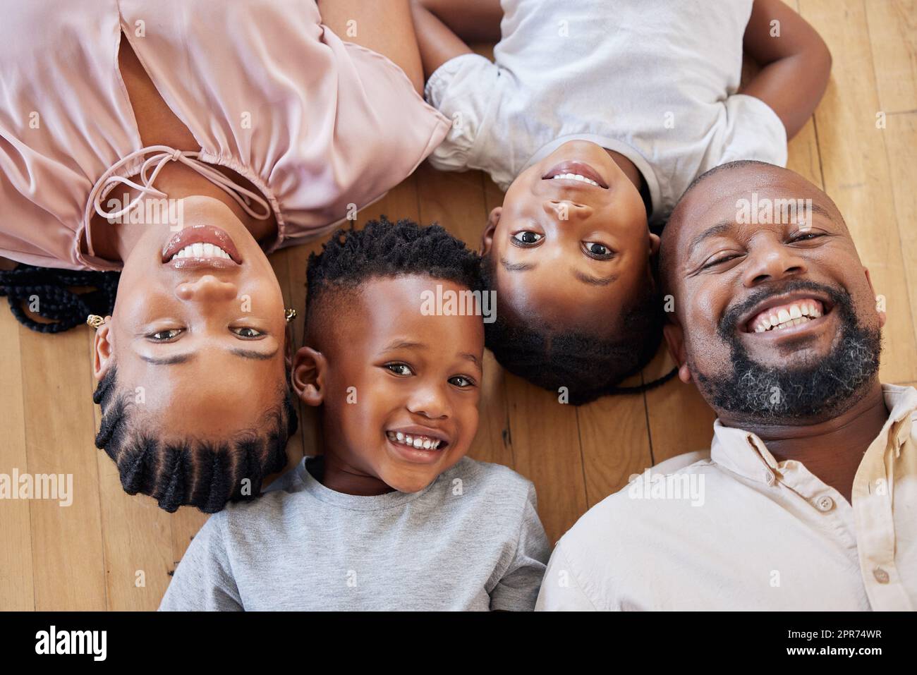 Happy african american family relaxing together and bonding at home. Little brother and sister spending time with their parents. Family showing their bright smiles and white teeth with their children Stock Photo