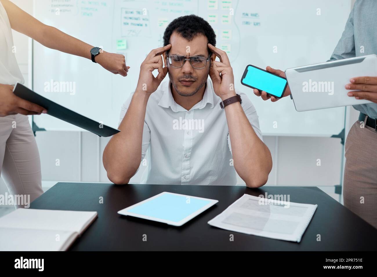Please go away. Shot of a young businessman looking stressed out while working in a demanding office environment. Stock Photo