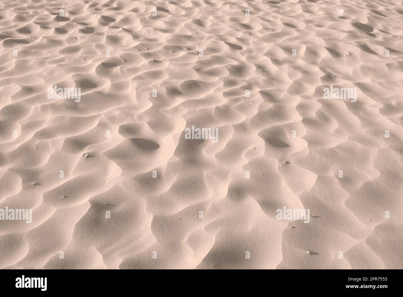 Sand beach texture background on summer season, dry sand on the seashore, desert. Beach sand - the art of nature. Sand dune desert. The uneven surface of a sea beach. Nature close-up abstract. Stock Photo