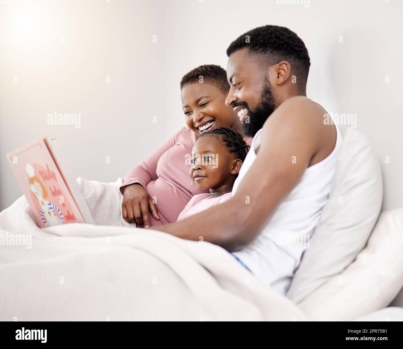Were unavailable to the world today. Shot of a young family bonding in bed together. Stock Photo