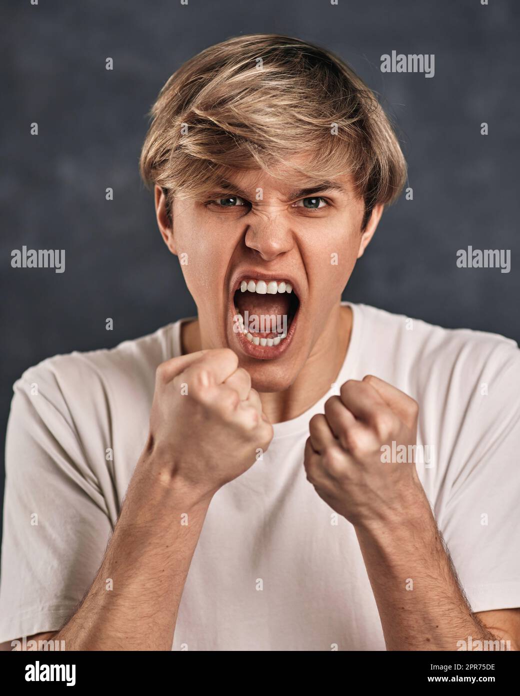 young guy in tshirt standing with boxing gesture and punching to