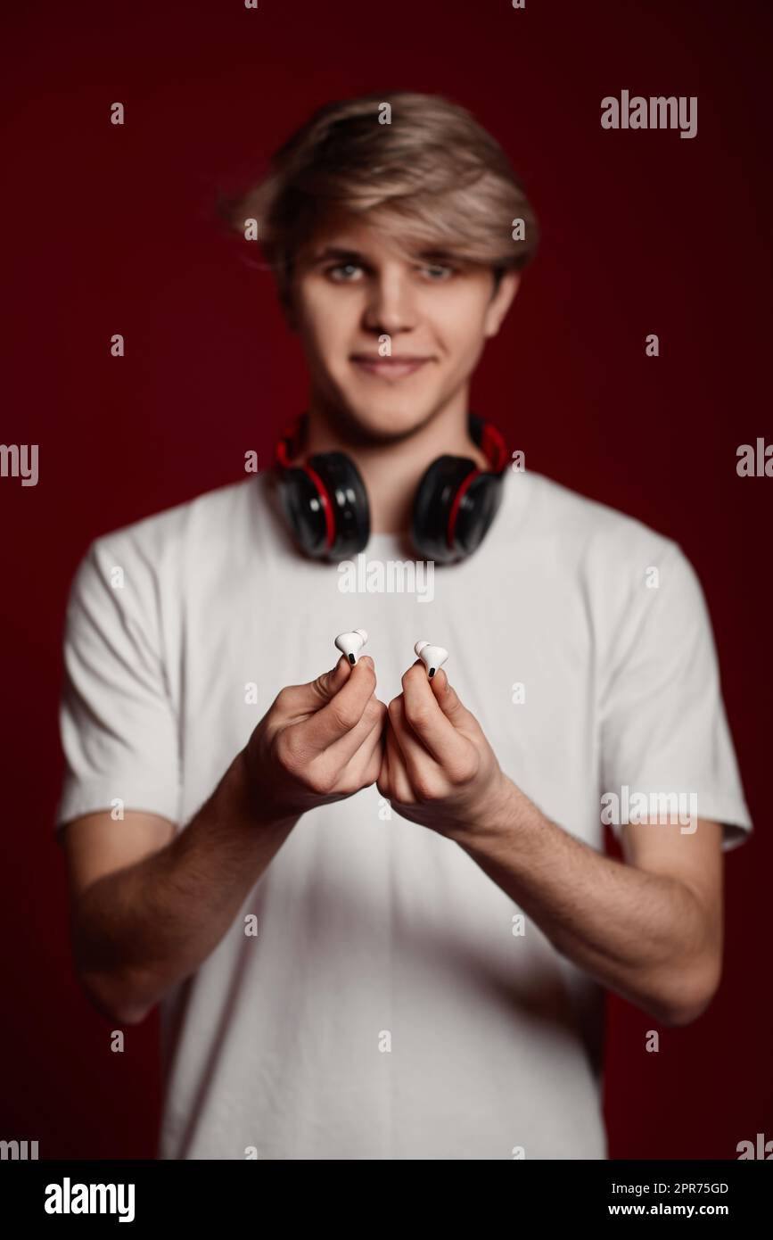 young man in white t-shirt gives modern earphones Stock Photo