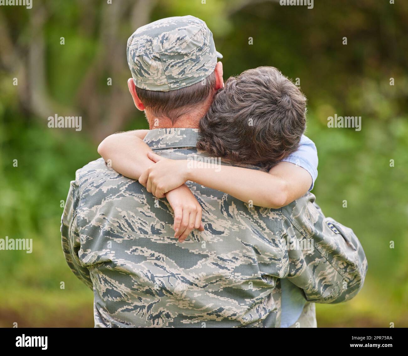 Shot of a father returning from the army hugging his son outside ...