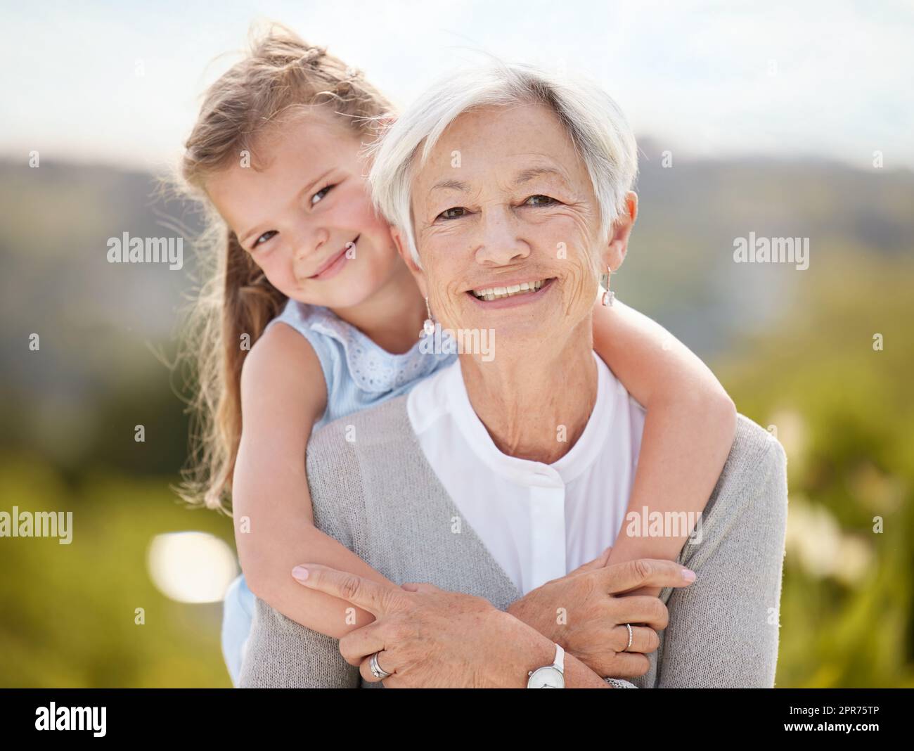 All happy families are alike. Shot of an elderly woman spending time outdoors with her granddaughter. Stock Photo