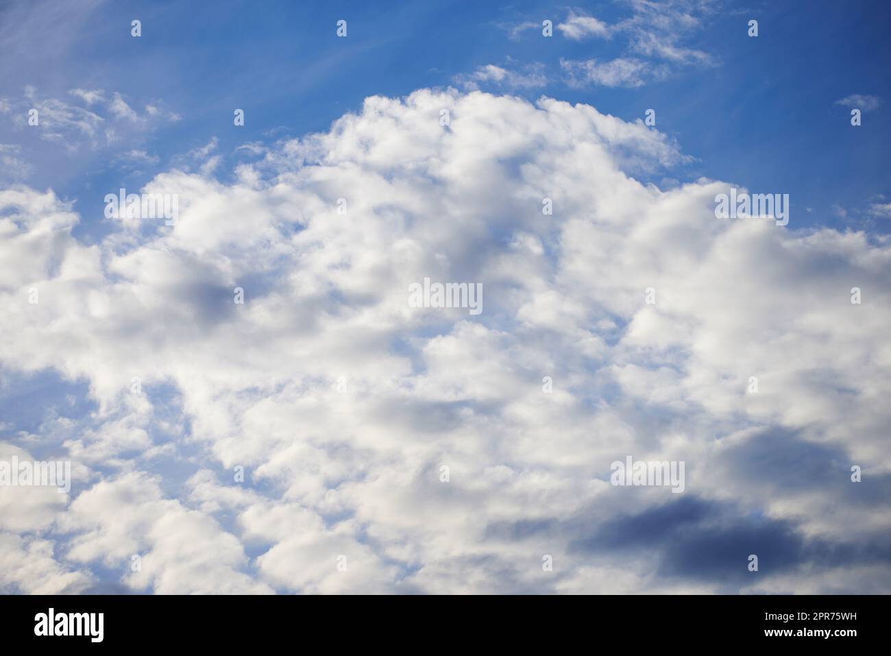 Light clouds in a beautiful blue sky with copy space background. A beautiful clear summer sky with sunshine and a white soft textured cloudscape in nature. Calming skies clearing up on a sunny day Stock Photo