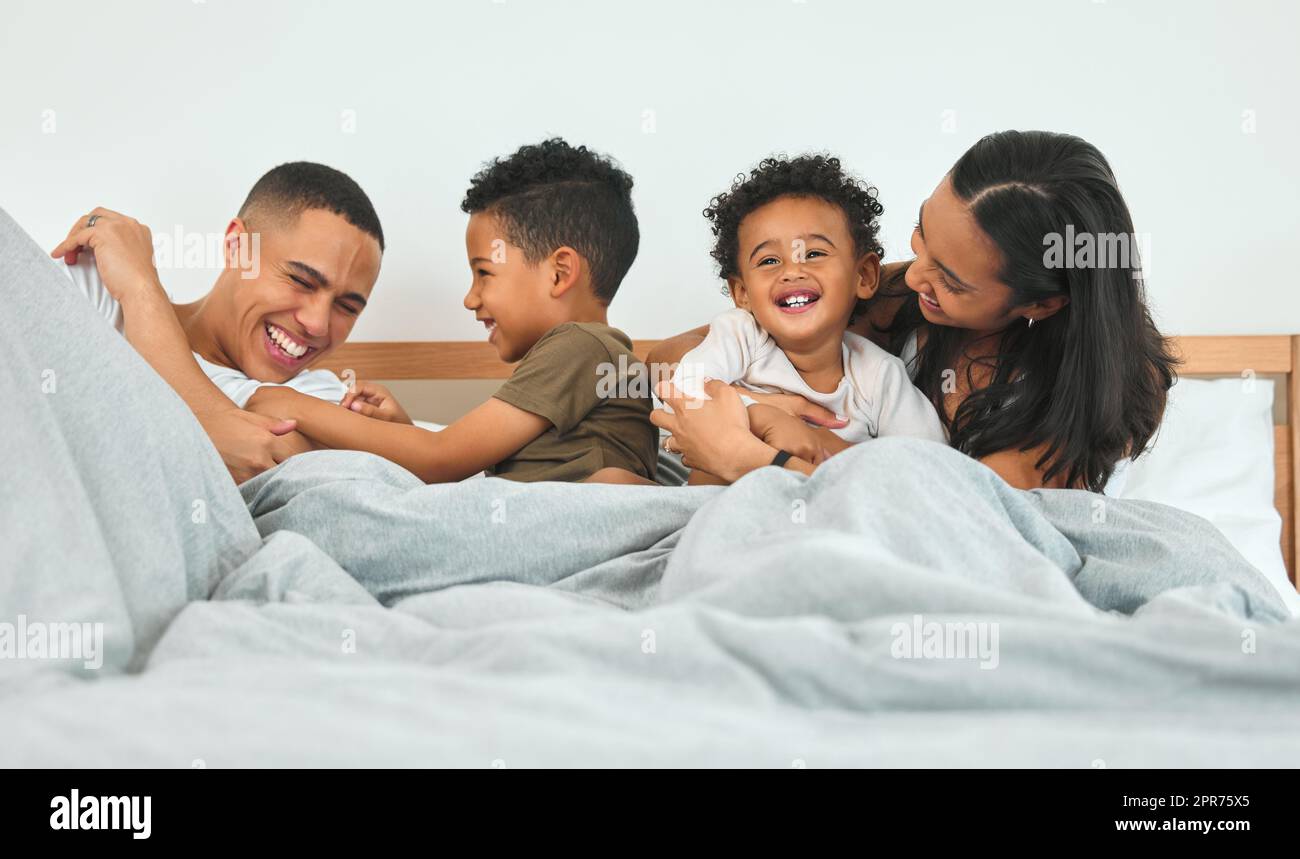 Early morning playtime. Shot of a young family relaxing together at home. Stock Photo