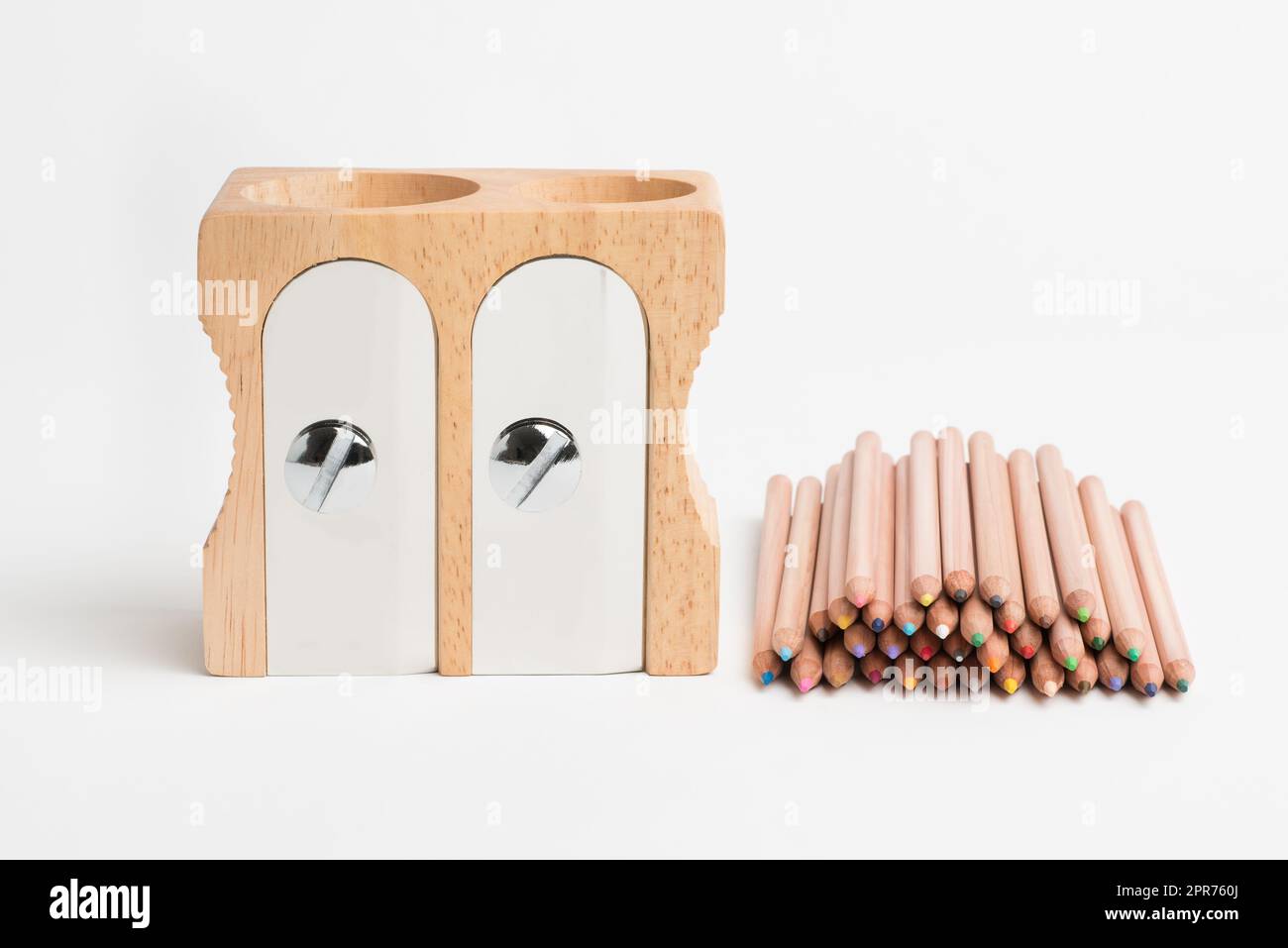 Keep it sharp, make your mark. Studio shot of a wooden sharpener and pencils. Stock Photo