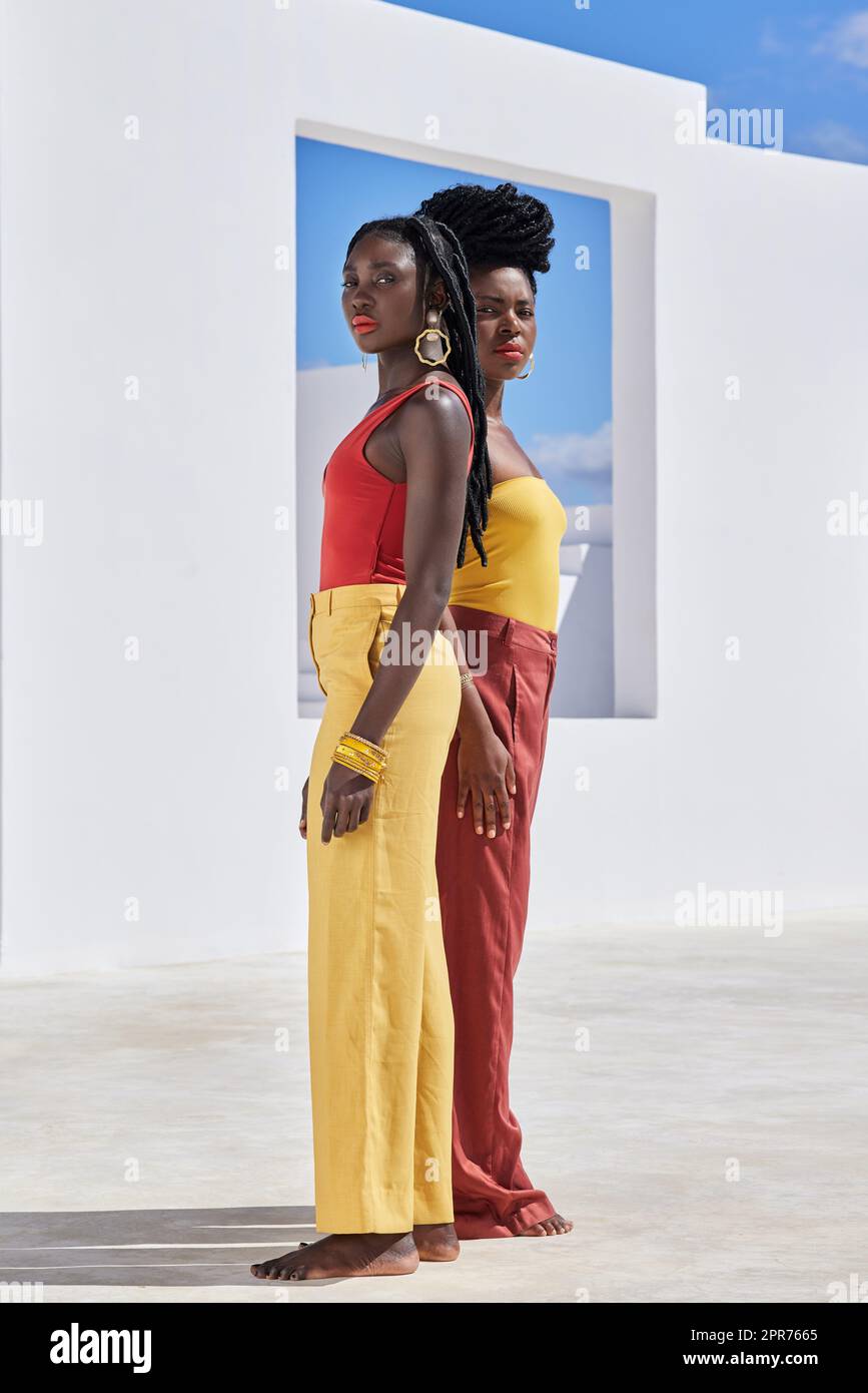 Summer is the season colour. Full length portrait of two attractive young women posing on a rooftop outdoors. Stock Photo