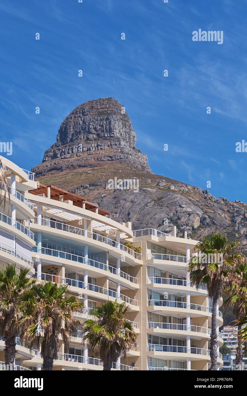 Copy space of Lions Head in Cape Town South Africa against a blue sky background from below. Panoramic of an iconic landmark and travel destination close to coastal apartment buildings and properties Stock Photo