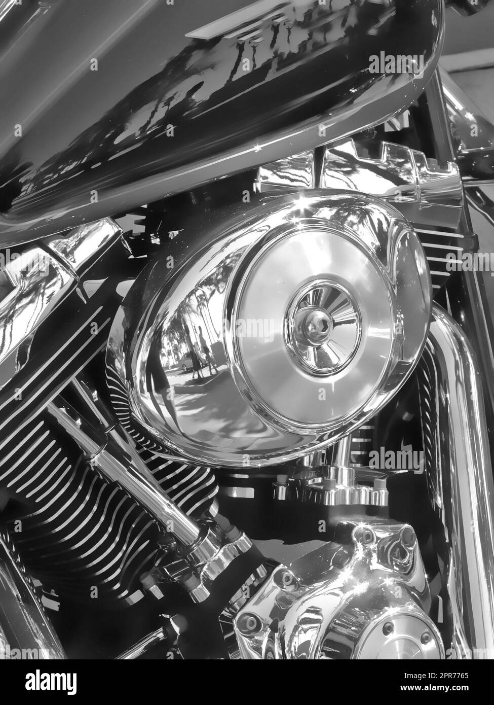 Closeup of metallic motorcycle engine details. A classic, shiny chrome motorbike engine at a motorcycle repair shop. Zoom in on a silver design, black motorbike during annual service at a garage Stock Photo