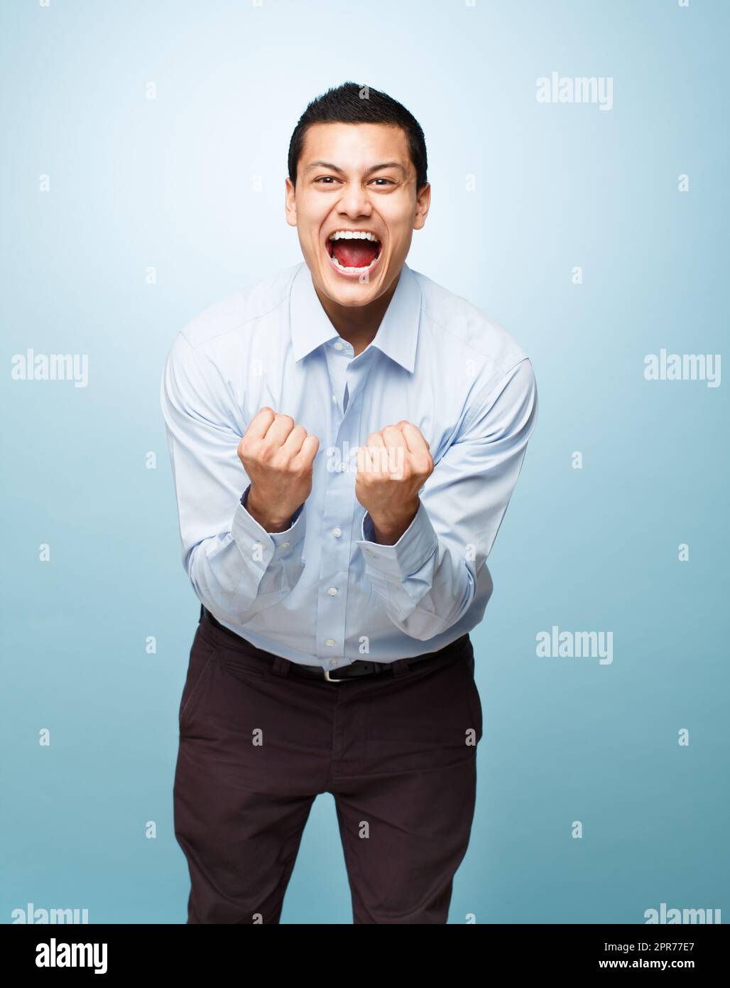 Express your excitement about life. Shot of a young man shouting in joy against a studio background. Stock Photo