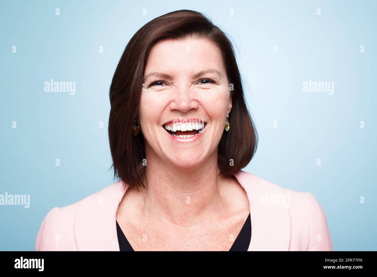 Spreading love and joy. Shot of a mature woman smiling against a studio background. Stock Photo