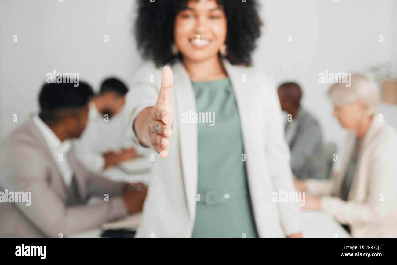 Giving you a warm welcome. Shot of a young businesswoman extending her hand out for a handshake at work. Stock Photo