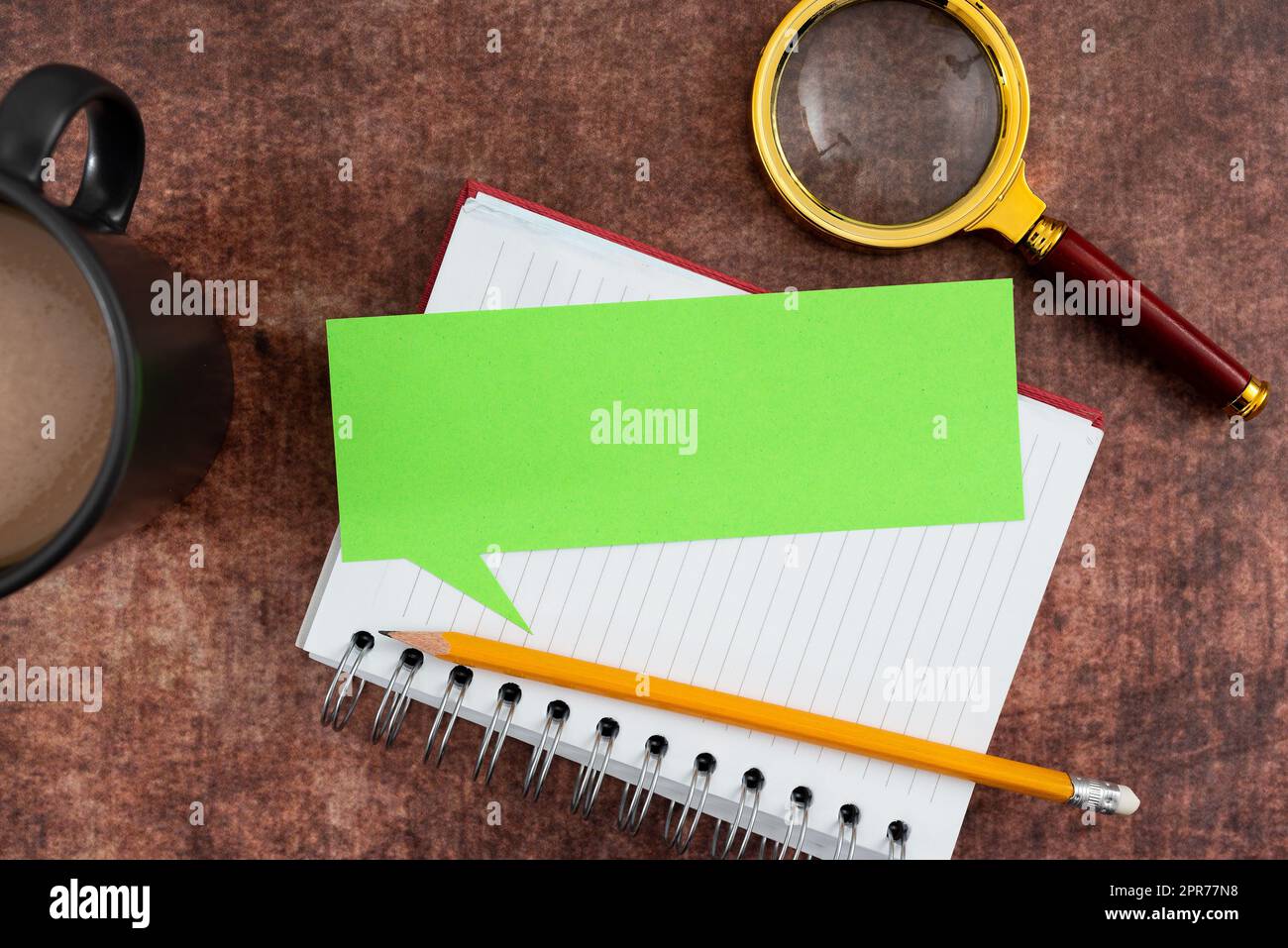 Blank Paper In Thought Bubble Shape With Spiral Book, Pencil, Coffee Mug And Magnifying Glass Wood. It Is Representing Researching And Brainstorming Of New Business Ideas. Stock Photo