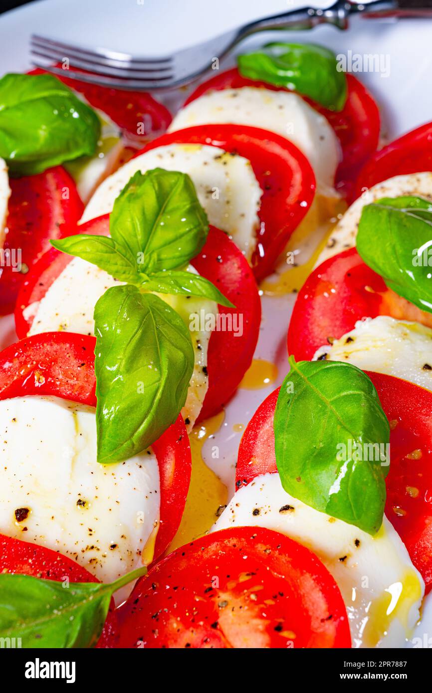 Tomato with mozzarella and basil Stock Photo - Alamy