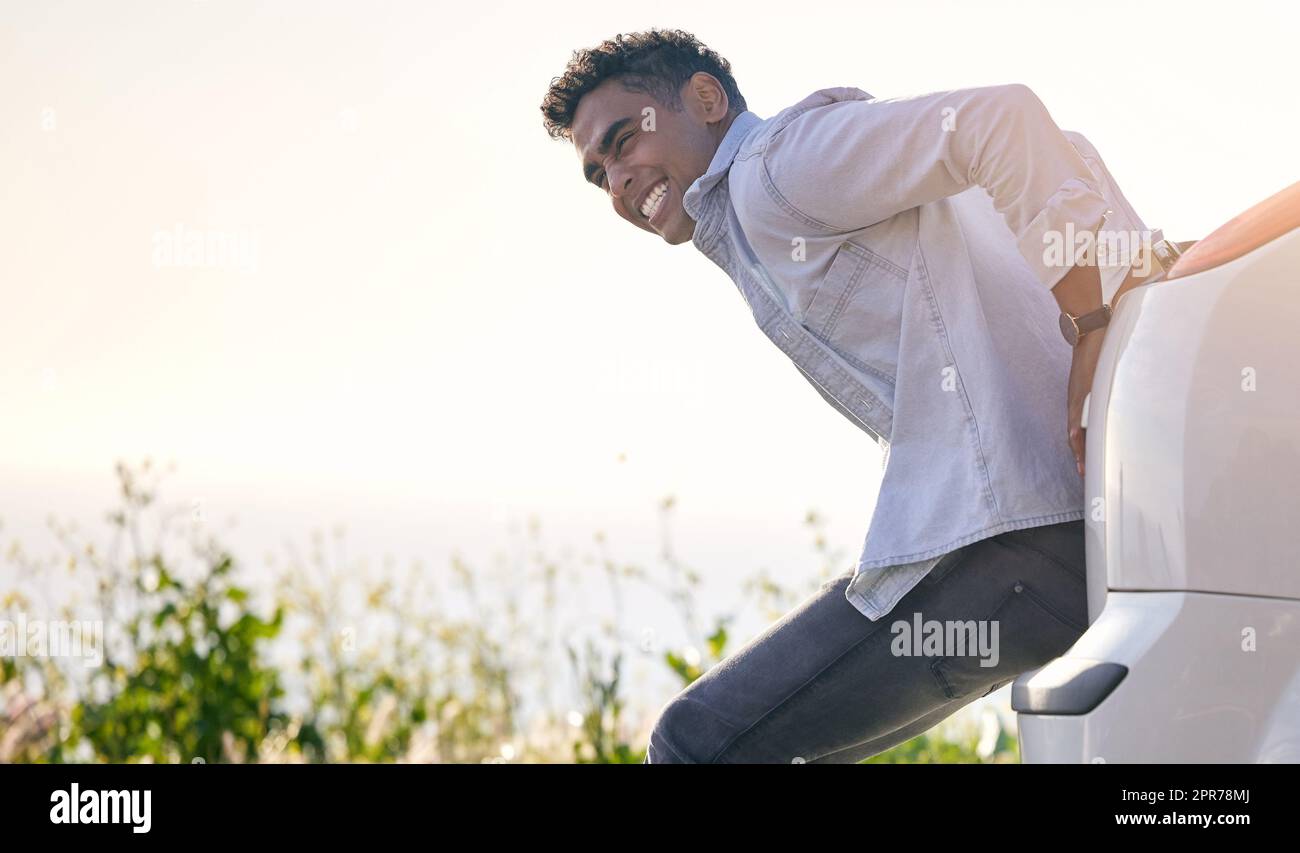 Maybe a push will help.... Full length shot of a handdsome young man pushing his car after suffering a vehicle breakdown. Stock Photo