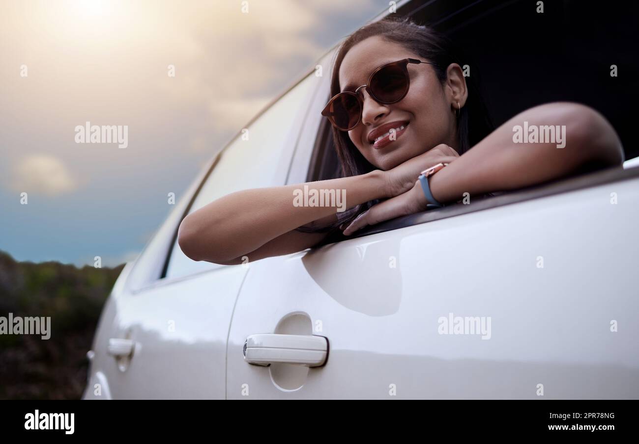 The road is where my heart is. Shot of a beautiful young woman enjoying an adventurous ride in a car. Stock Photo