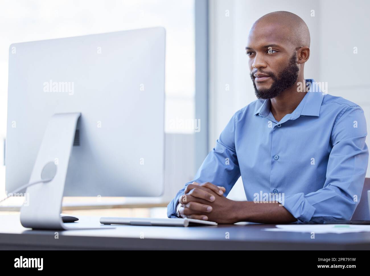 His minds in the right place. Shot of a young businessman using a computer at work. Stock Photo