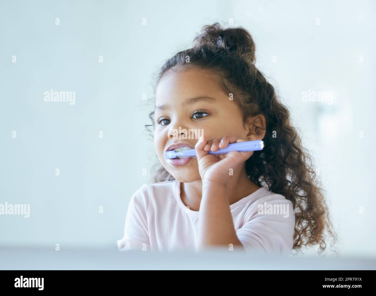Getting minty fresh breath. Shot of a little girl brushing her teeth in a bathroom at home. Stock Photo