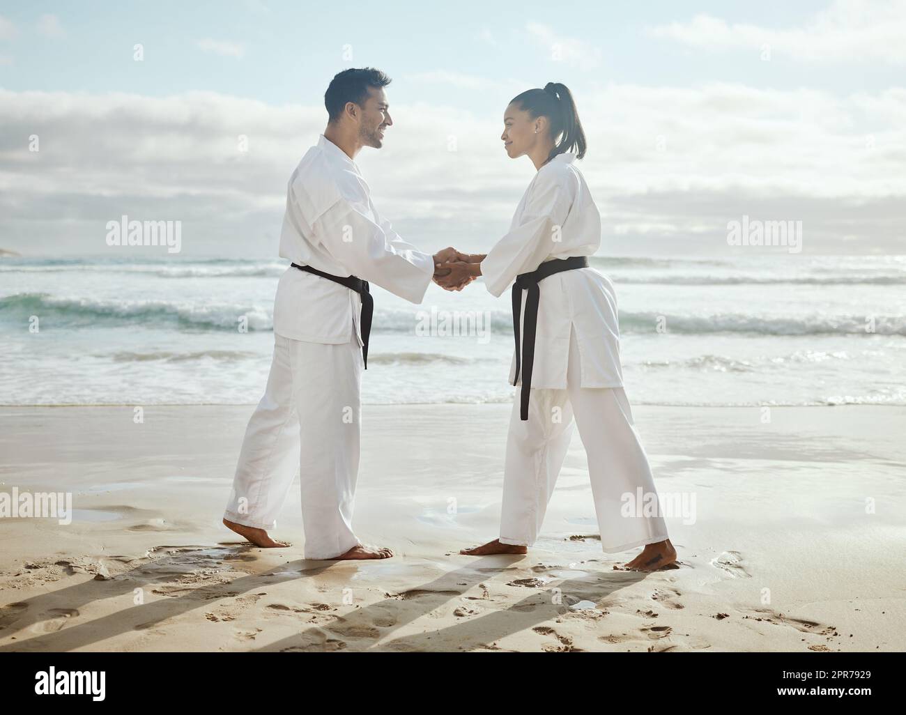 Great work today. Full length shot of two young martial artists practicing karate on the beach. Stock Photo