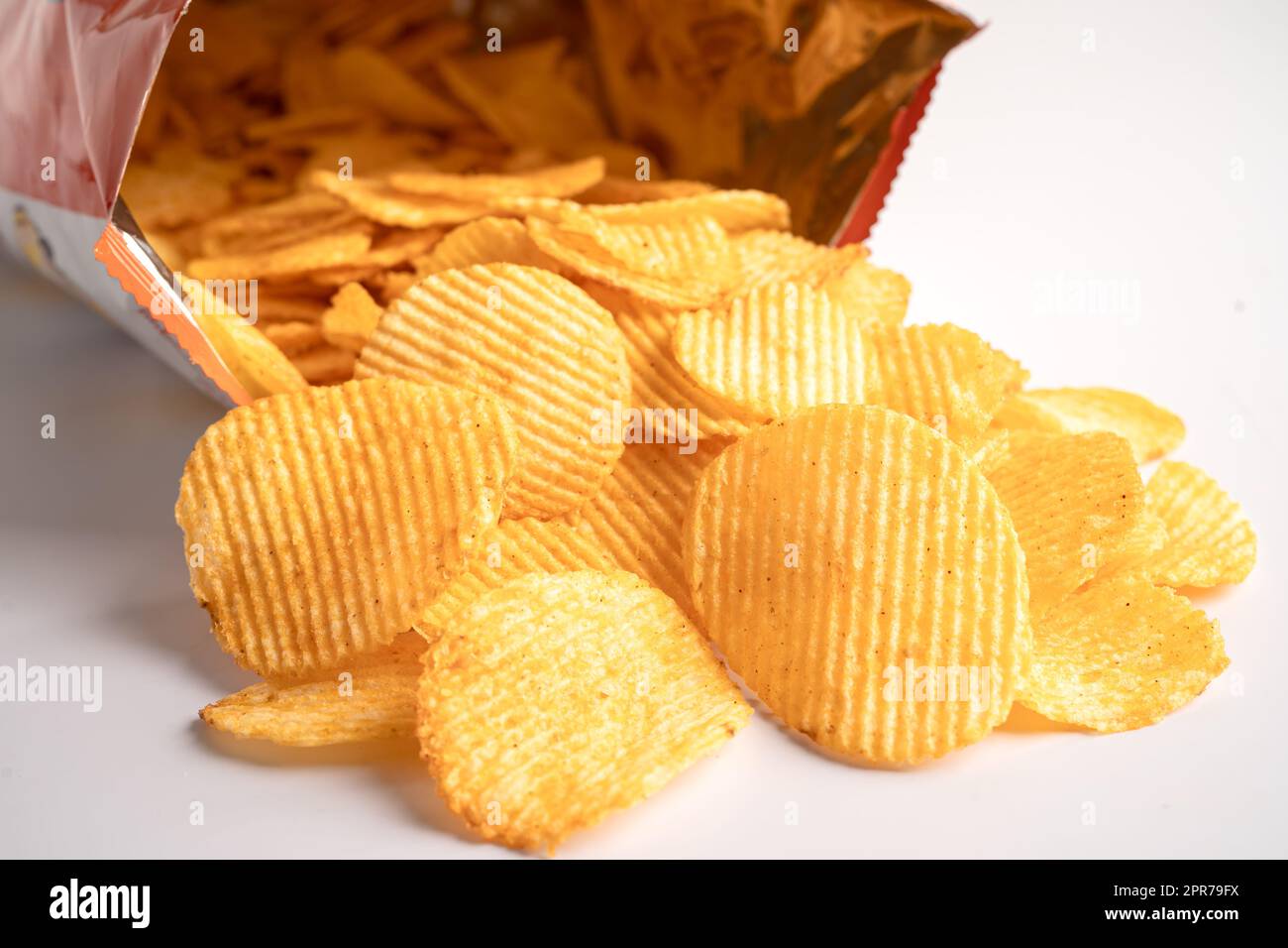 Potato chips, delicious BBQ seasoning spicy for crips, thin slice deep fried snack fast food in open bag. Stock Photo