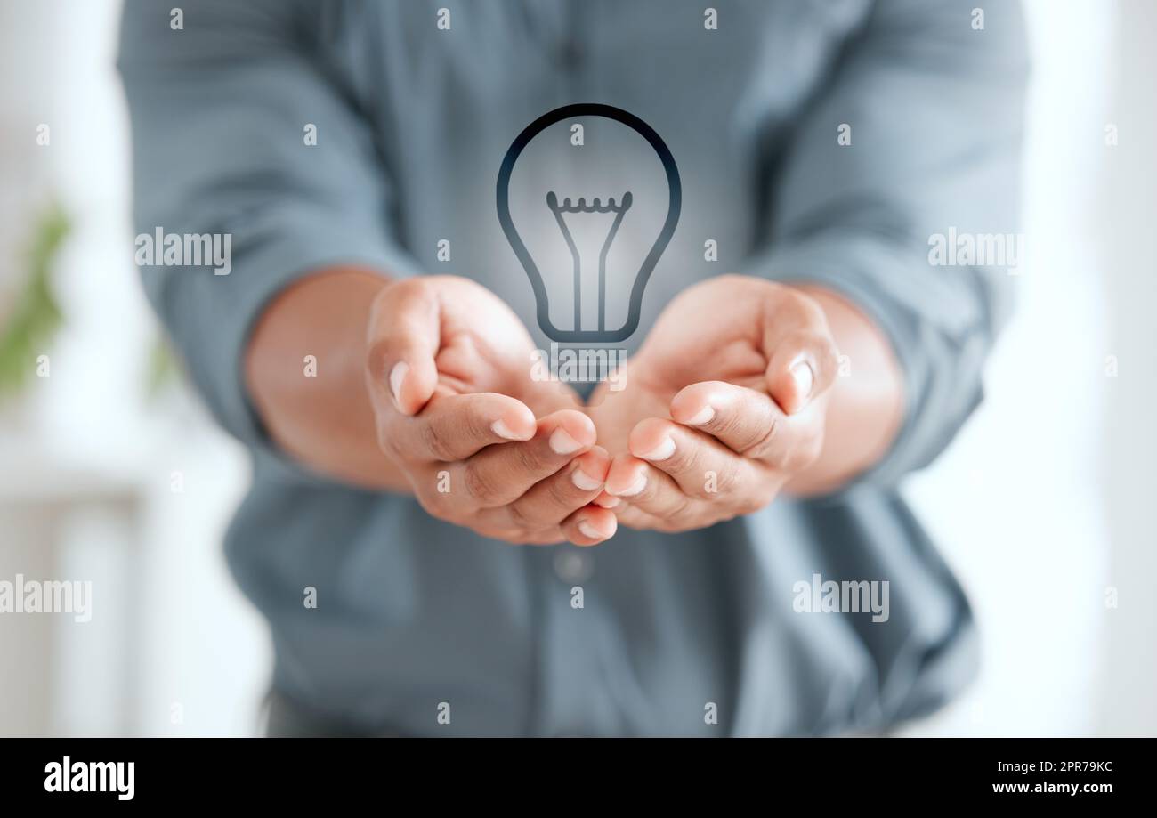 Take care of your energy. an unrecognizable businessperson holding out their hands with a lightbulb placed in it at work. Stock Photo