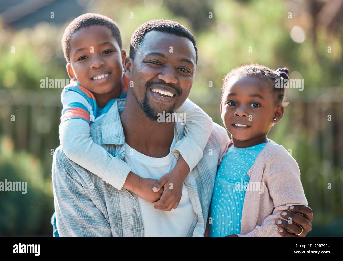 Father is a verb. Its something you do. Not just who you are. a man spending time outdoors with his two children. Stock Photo