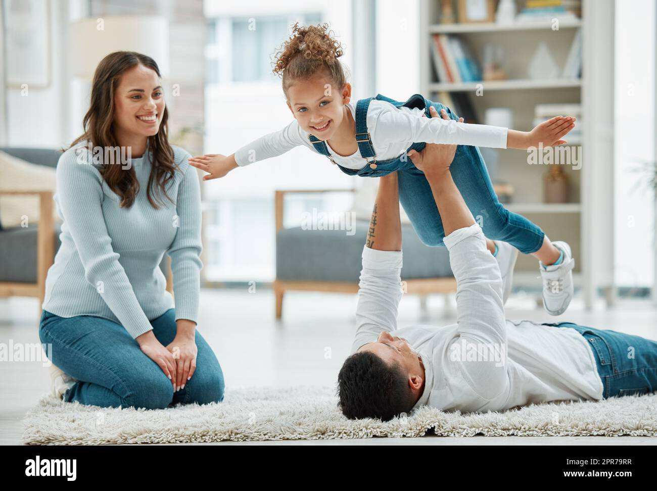 Flying high with dad. a young family playing together at home. Stock Photo