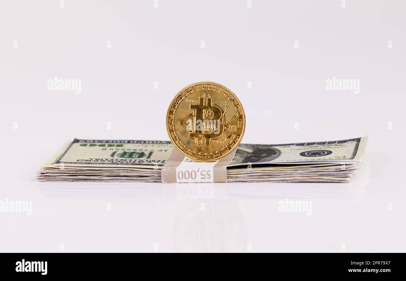 Dont tell me what you value, show me your budget. a coin and a wad of cash against a grey background. Stock Photo