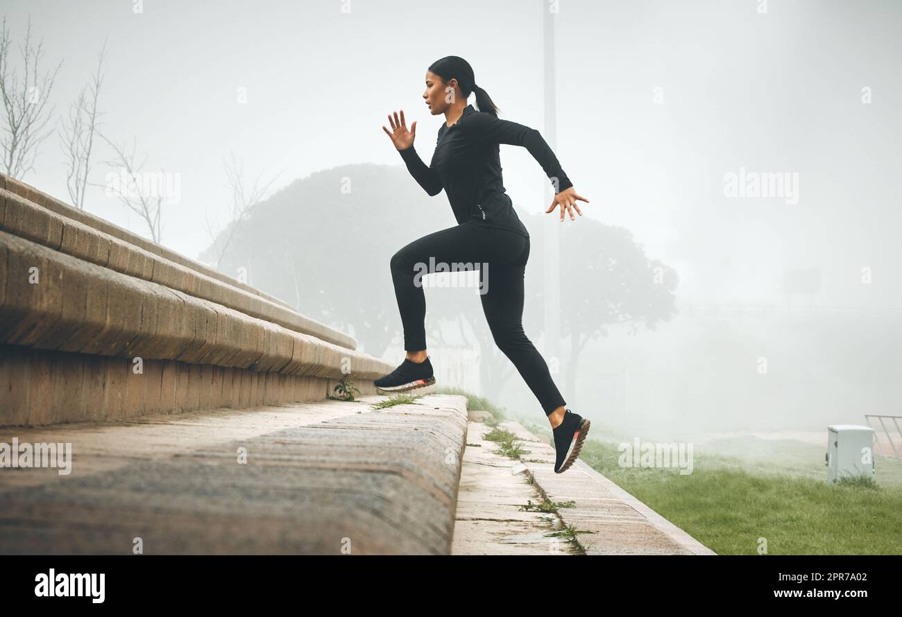 Every step counts for something. a sporty young woman running up steps outdoors. Stock Photo